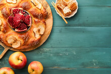 Jewish Holidays - Rosh Hashanah Or Rosh Hashana. Pomegranate, Apples, Honey And Round Challah On  Old Wooden Blue Table Background. Jewish Autumn Celebration. Shana Tova. Yom Kippur Concept. Top View