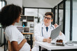 © Nuttapong punna - Doctor and patient discussing something while sitting at the table . Medicine and health care concept.