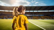 © Stock'd  - back view of little girl on pitch watching australian team at women's world cup in stadium wearing yellow and green