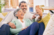 © LuneVA/peopleimages.com - Mature couple, laugh and phone in home of social media post, meme or mobile app subscription. Happy man, woman and reading funny joke on internet, scroll on smartphone or relax on sofa in living room