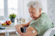 © Halfpoint - Diabetic senior patient checking blood glucose level at home using continuous glucose monitor.