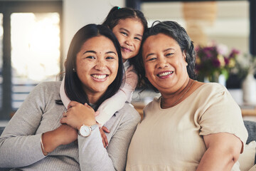 Wall Mural - Happy, women and generations with portrait of family on sofa for smile, bonding and support. Hug, relax and grandparent with mother and child in living room at home for calm, care and peace together