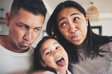 Canvas Print - Selfie, silly and portrait of girl with her parents bonding in the living room of their home. Goofy, happy and child taking a picture with her mother and father with funny faces at their family house