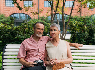 Sticker - Aged couple sitting on a bench in the park