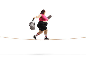 Sticker - Side shot of an overweight woman with a sports bag and ezercise mat walking on a tightrope