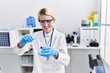 © Krakenimages.com - Young blonde woman scientist pouring liquid on test tube at laboratory