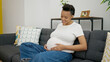 © Krakenimages.com - Young pregnant woman touching belly sitting on sofa at home