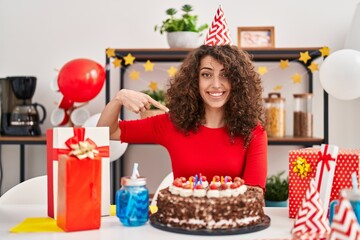 Sticker - Hispanic woman with curly hair celebrating birthday holding big chocolate cake pointing finger to one self smiling happy and proud