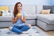 © Krakenimages.com - Young woman drinking coffee sitting on floor at home