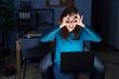© Krakenimages.com - Brunette woman working at the office at night doing ok gesture like binoculars sticking tongue out, eyes looking through fingers. crazy expression.