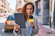 © Krakenimages.com - Young woman reporter working using microphone and touchpad at street