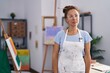 © Krakenimages.com - Brunette woman painting at art studio with serious expression on face. simple and natural looking at the camera.