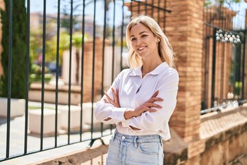 Sticker - Young blonde woman smiling confident standing with arms crossed gesture at street