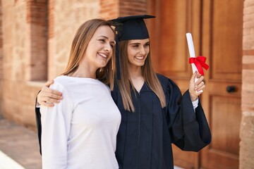 Canvas Print - Two women mother and graduated daughter standing together at campus university