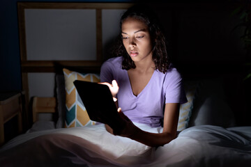 Wall Mural - Young african american woman using touchpad sitting on bed at bedroom