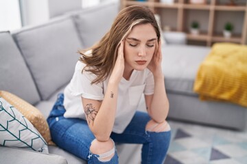 Sticker - Young woman stressed sitting on sofa at home