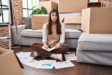 Poster - Young brunette woman moving to a new home doing finances thinking attitude and sober expression looking self confident