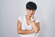 © Krakenimages.com - Young asian woman with short hair standing over isolated background thinking looking tired and bored with depression problems with crossed arms.