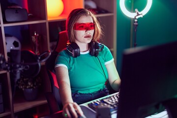 Poster - Young redhead woman streamer playing video game using virtual reality glasses at gaming room