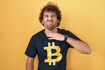 Sticker - Hispanic young man wearing bitcoin t shirt cutting throat with hand as knife, threaten aggression with furious violence