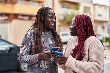 Poster - African american women friends smiling confident using smartphone at street