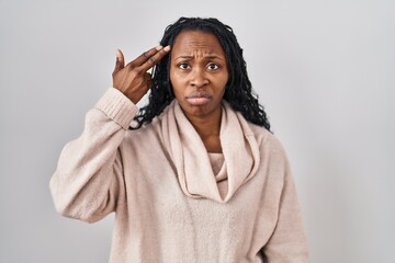 Sticker - African woman standing over white background shooting and killing oneself pointing hand and fingers to head like gun, suicide gesture.