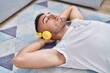 © Krakenimages.com - Young hispanic man listening to music lying on floor at home