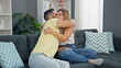 © Krakenimages.com - Man and woman couple hugging each other sitting on sofa at home