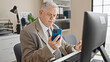 © Krakenimages.com - Middle age grey-haired man business worker using computer and smartphone at office