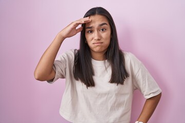 Canvas Print - Young hispanic woman standing over pink background worried and stressed about a problem with hand on forehead, nervous and anxious for crisis