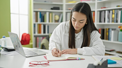 Poster - Young beautiful hispanic woman student using laptop writing notes at university classroom