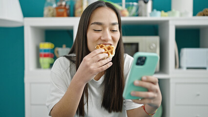 Poster - Young beautiful hispanic woman eating waffle using smartphone at dinning room