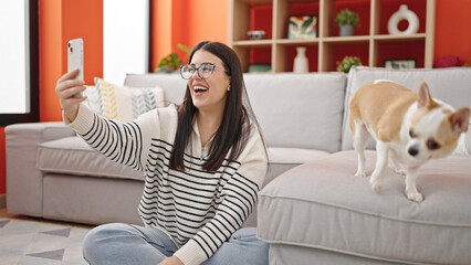 Canvas Print - Young hispanic woman with chihuahua dog sitting on the floor taking selfie together at home