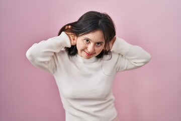 Sticker - Woman with down syndrome standing over pink background trying to hear both hands on ear gesture, curious for gossip. hearing problem, deaf