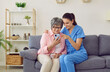 © Studio Romantic - Young nurse helping a senior woman learn to use a mobile phone. Friendly caregiver showing a happy old lady how to make videocalls. Helpful carer teaching an older woman how to use the modern gadget