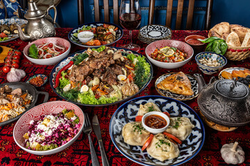 Traditional Uzbek oriental cuisine. Uzbek family table from different dishes for the New Year holiday. The background image is a top view.