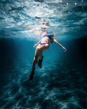 Woman With Diving Fins Swimming In The Sea