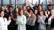 © Katsiaryna - Group of young businesswomen smiling happy and clapping. Standing and looking to the camera at the office.