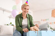© Pixel-Shot - Mature woman taking birthday gift from bag at home