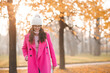 © morrowlight - Happy stylish woman wear pink autumn jacket and knitted hat walk on city street outdoor. Fall season.