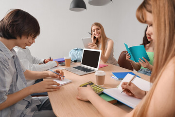 Wall Mural - Group of students doing homework at table in room