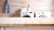 © Tetiana - Empty wooden board with towels on blurred background of washing machine in home laundry. Place for product mounting and advertising