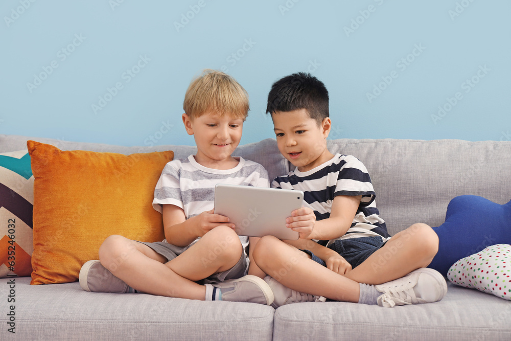 Cute little boys playing with tablet computer at home