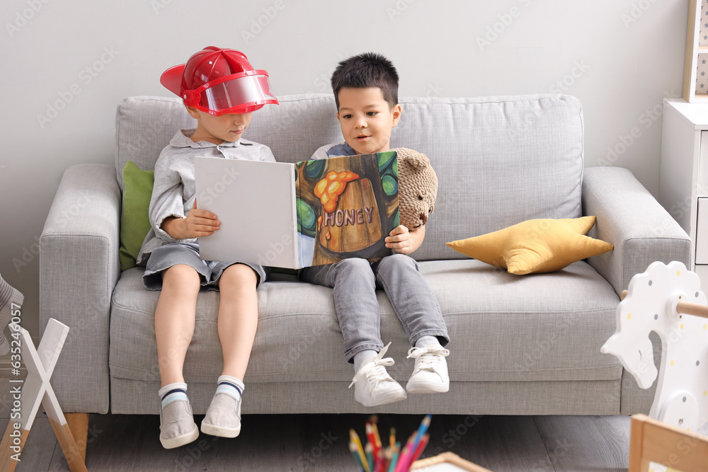 Cute little boys reading story at home