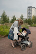 © ADDICTIVE STOCK - Woman putting baby to sleep in buggy at park during summer