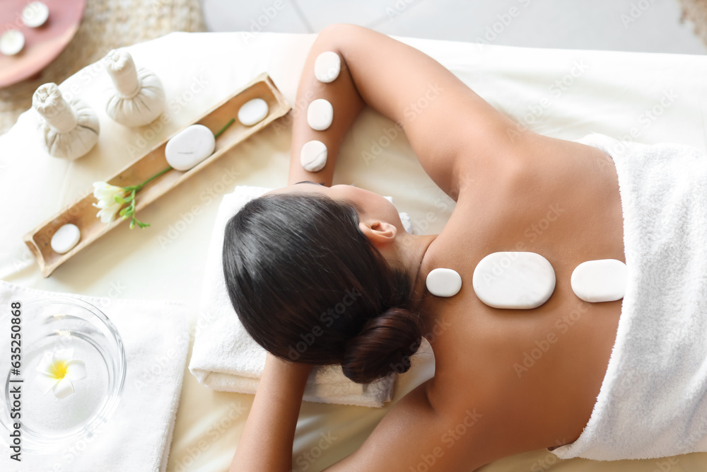 Attractive woman relaxing in spa salon, top view