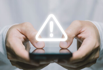 Wall Mural - businessman using laptop showing warning triangle and exclamation sign icon warning of dangerous pro