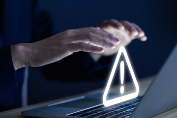 Wall Mural - businessman using laptop showing warning triangle and exclamation sign icon warning of dangerous pro