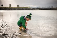 Child Playing On Rocky Coast In Hawke's Bay, New Zealand