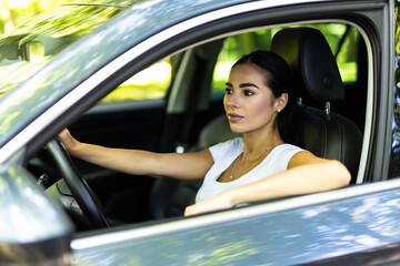 Wall Mural - Beautiful young smiling woman driving her car.